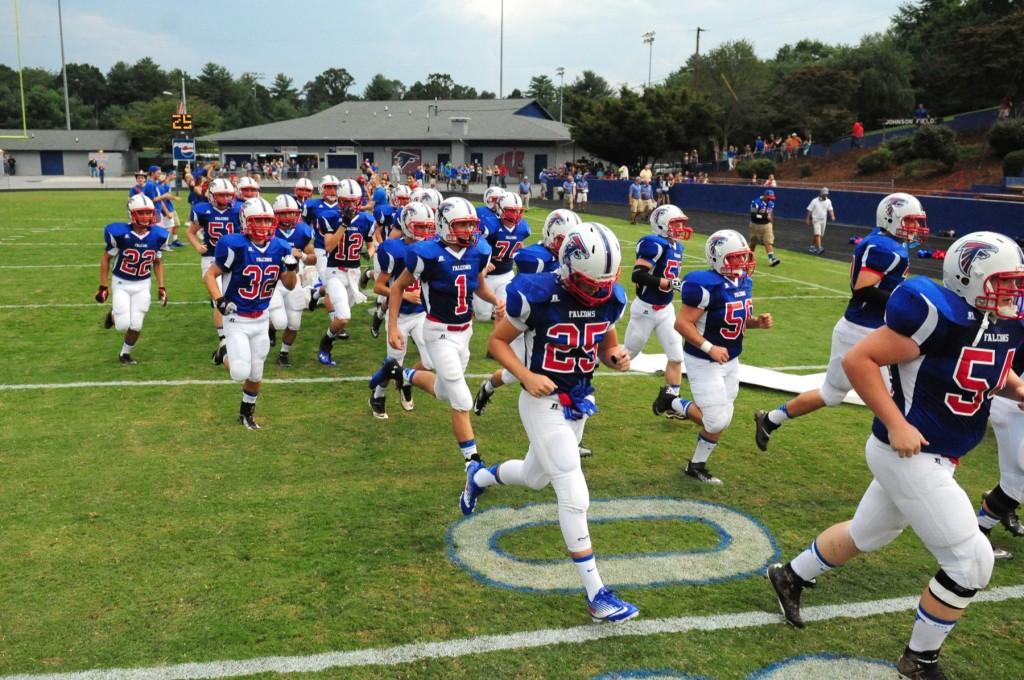 Above, the West's Football team storms the field in preparation for the game against East Henderson.