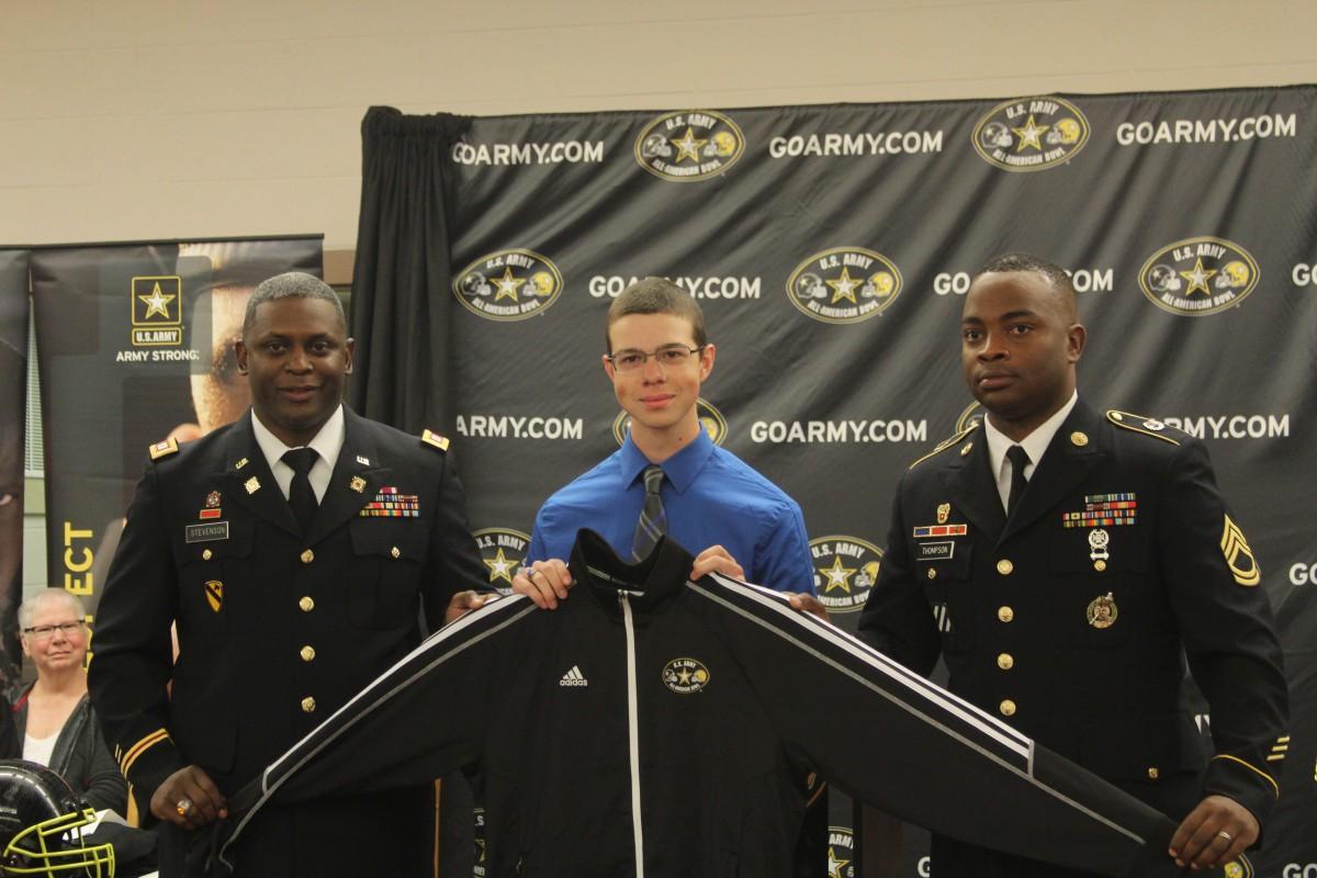 Representatives from the U.S. Army present senior Will  Hinchliffe with a jacket at a presentation to announce his acceptance into the Army All-American Bowl Marching Band on Oct. 2. Hinchliffe is a trombone player in the West Henderson Flying Falcon Marching Band and has also participated in all-county, and all-district bands. 