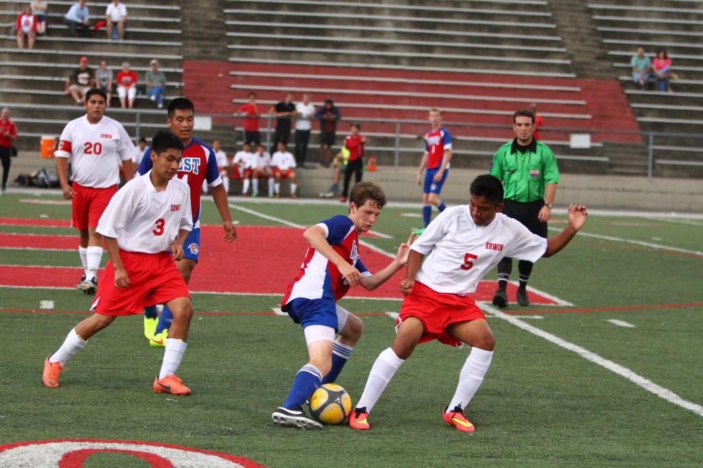 At an away game at nonconference Erwin, sophomore Trevor Laffin battles it out for a ball at midfield. The Falcons went on to earn a 3-2 win over the Warriors. “I was satisfied about getting the ball and representing my team,” Laffin said. Photo used by permission of Lifetouch.