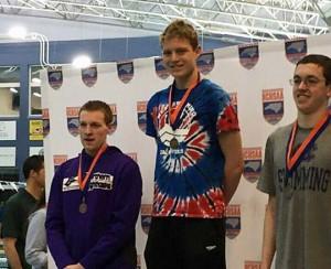 Sophomore Jake Johnson receives the first place award for the 100-yard backstroke at the North Carolina 3A Swimming finals. Johnson also received a third place award in the 200-yard freestyle and broke school records in both events. Photo taken from the Piranhas Facebook page. 