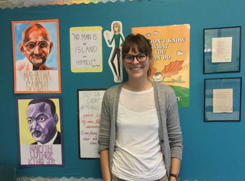 English teacher Amy Mildebrath next to her original art.