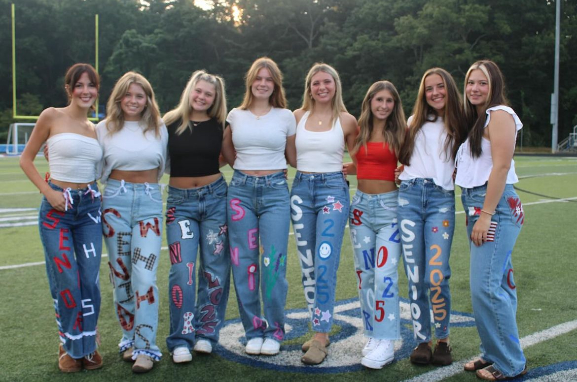 West Henderson seniors pose together to show off their painted jeans. Many designs included patterns of "Senior," and, "2025," in true West red, white, and blue. Photo courtesy of Haylee Bader.