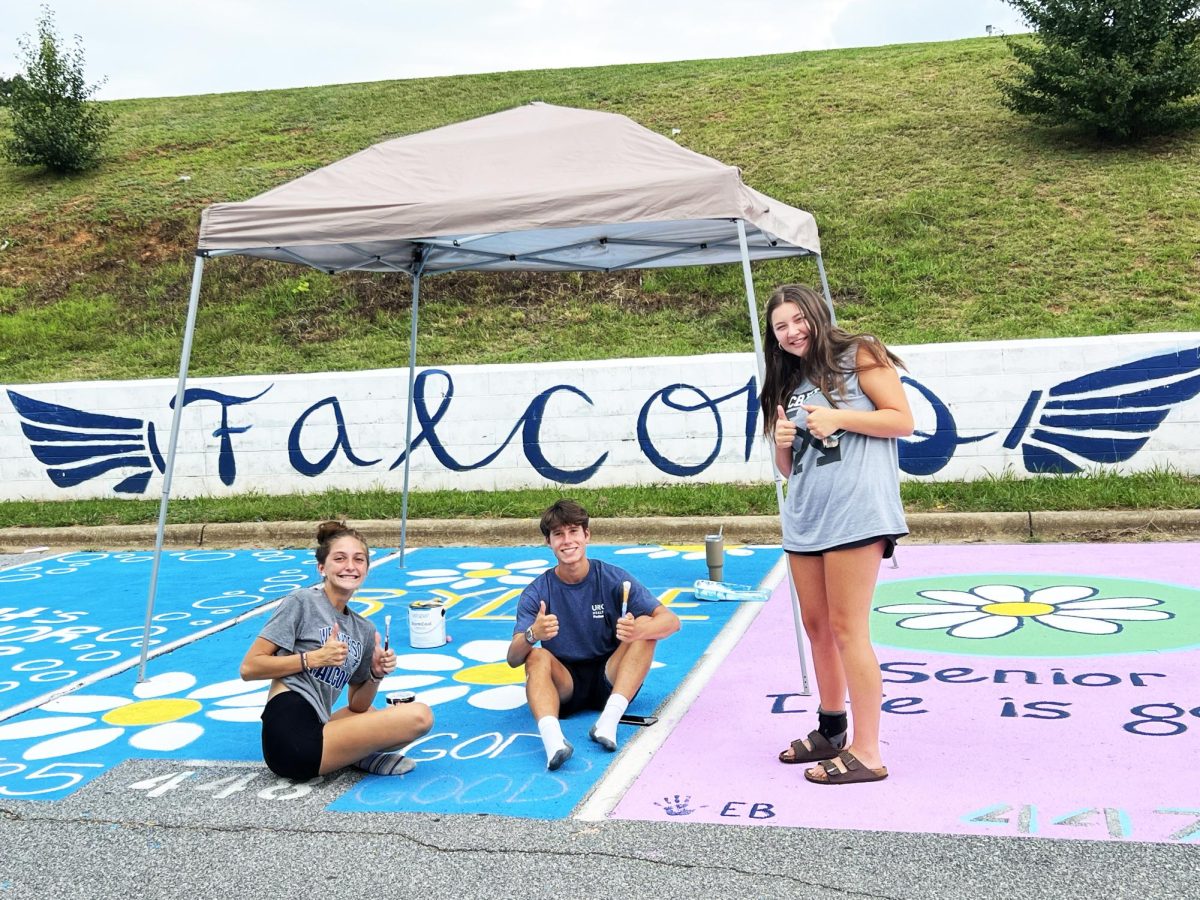 Eli Clonch, Haylee Bader and Rylee Lecker pose together for a photo while painting their senior spots. As the summer came to an end WHHS seniors came together to plan, sketch, and paint their spots. Clonch said, “My most memorable memory was running to get under a canopy when it started raining. All of the seniors were there together; nervous about our spots drying." (Photo by Ashley Ruzich)
